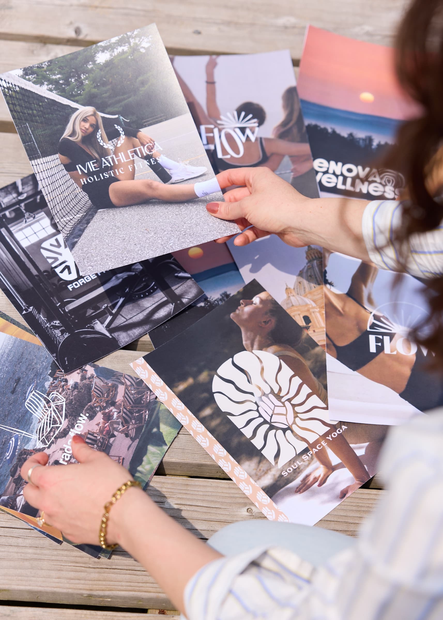 Printed wellness and fitness brand materials spread across a wooden dock during a review.