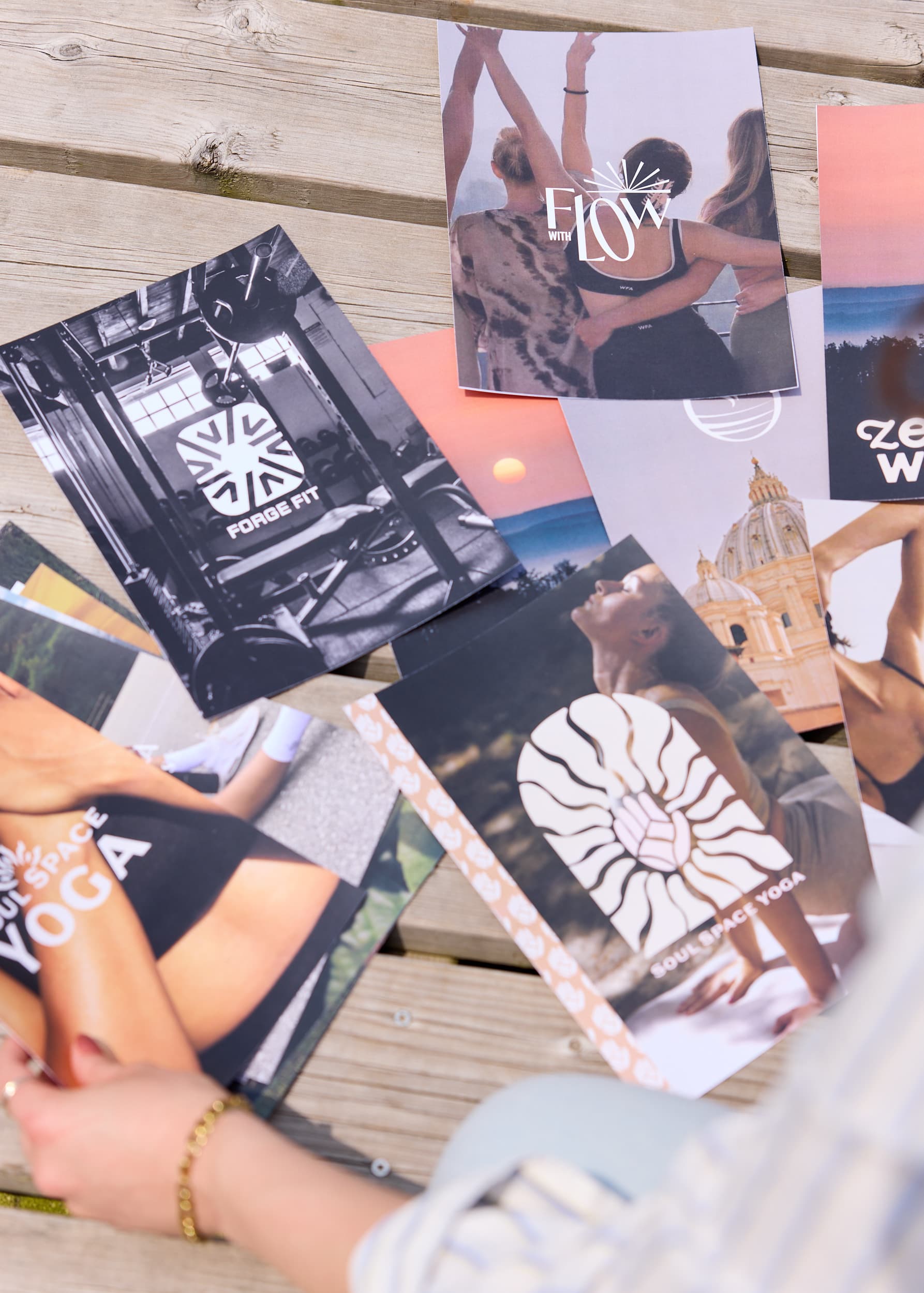 Printed wellness, fitness, and lifestyle brand concepts arranged together on a wooden table