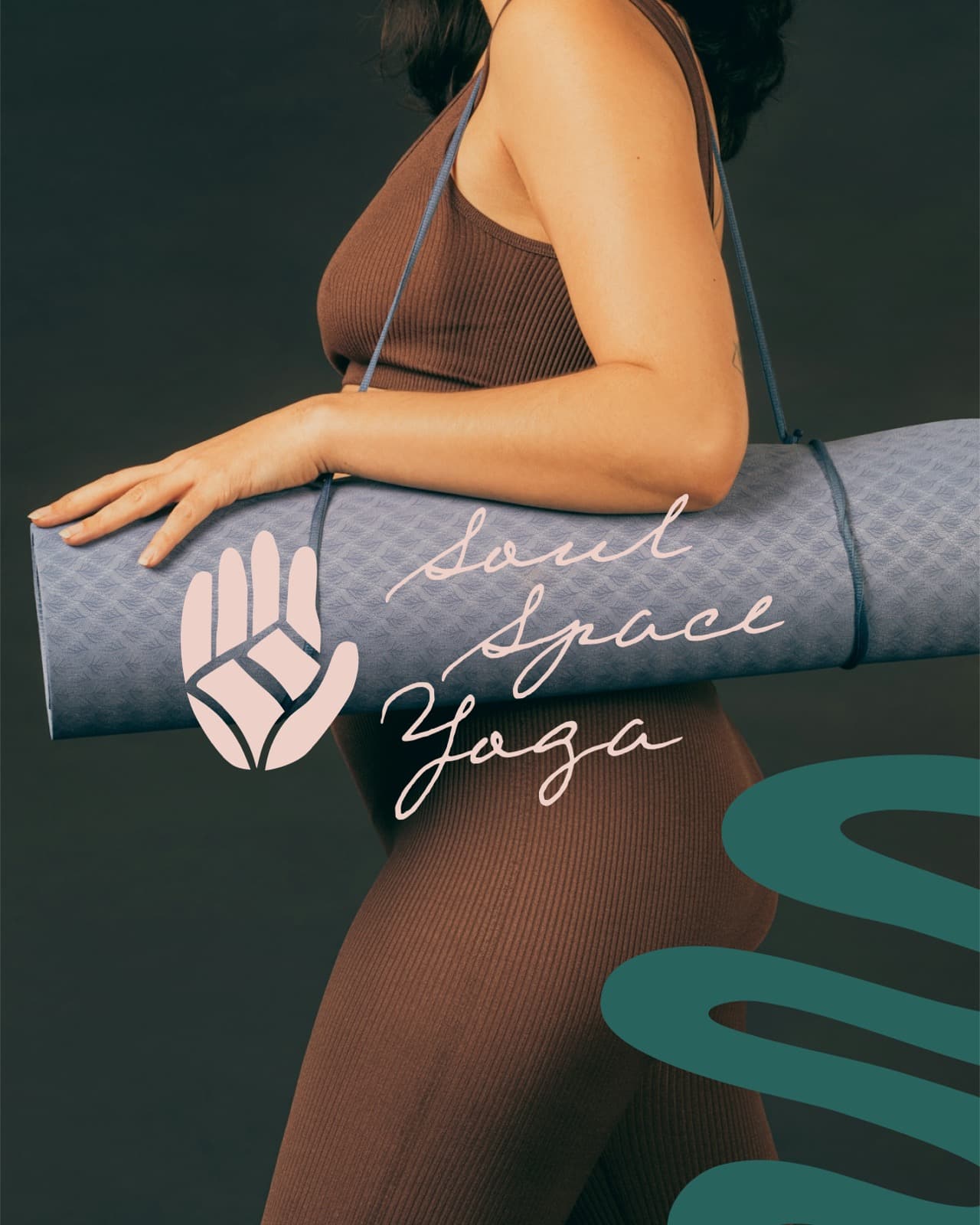 Person in brown athleticwear holding a dusty blue yoga mat with Soul Space Yoga script lockup and hand mark