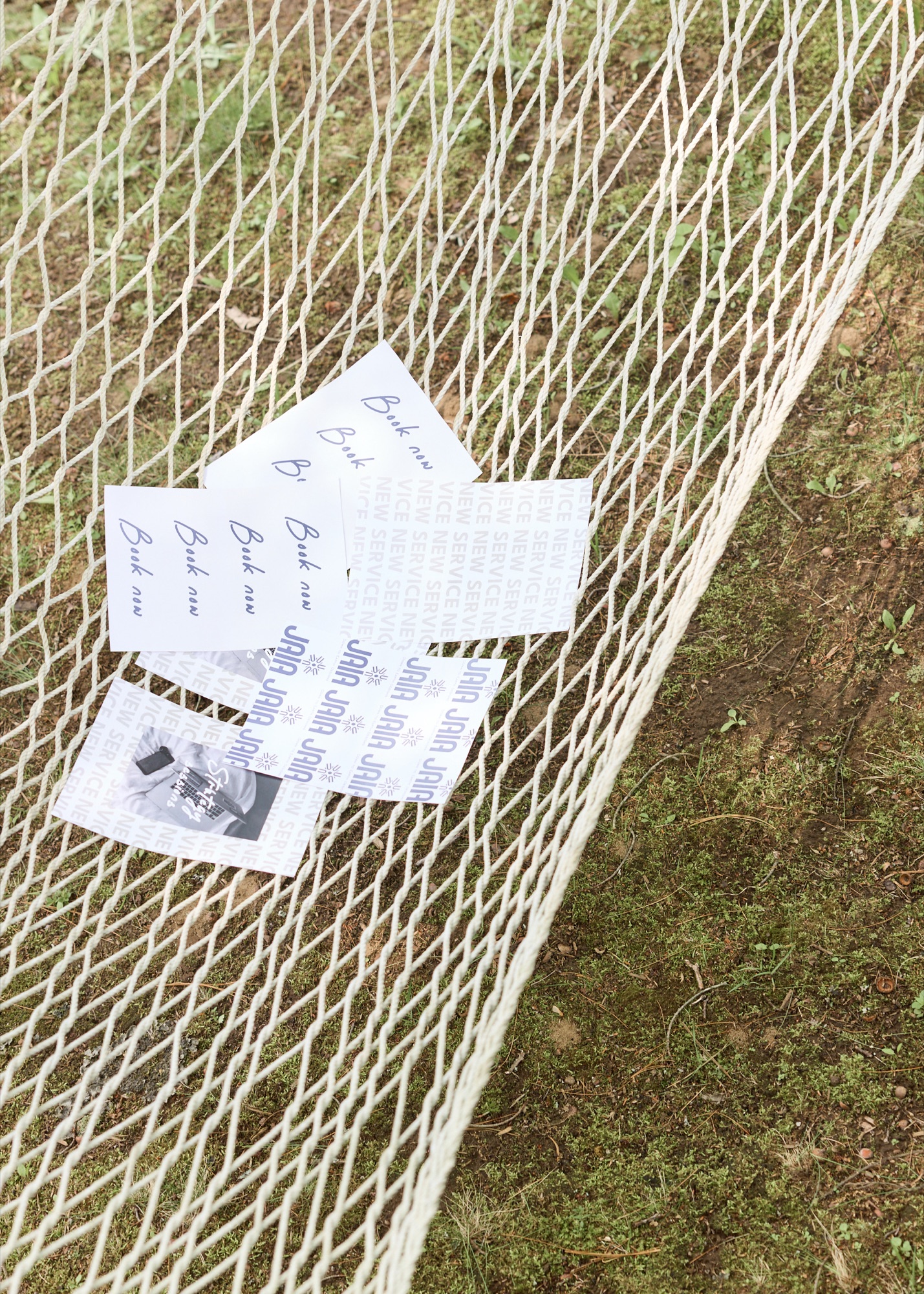 Printed brand cards and marketing pieces resting in an outdoor hammock, ready to use